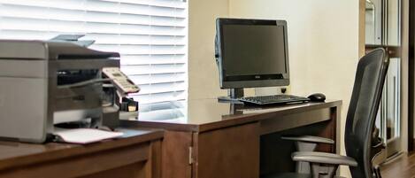 Un bureau d’ordinateur équipé d’un écran, d’un clavier et d’une souris, ainsi que d’une imprimante et d’une chaise.