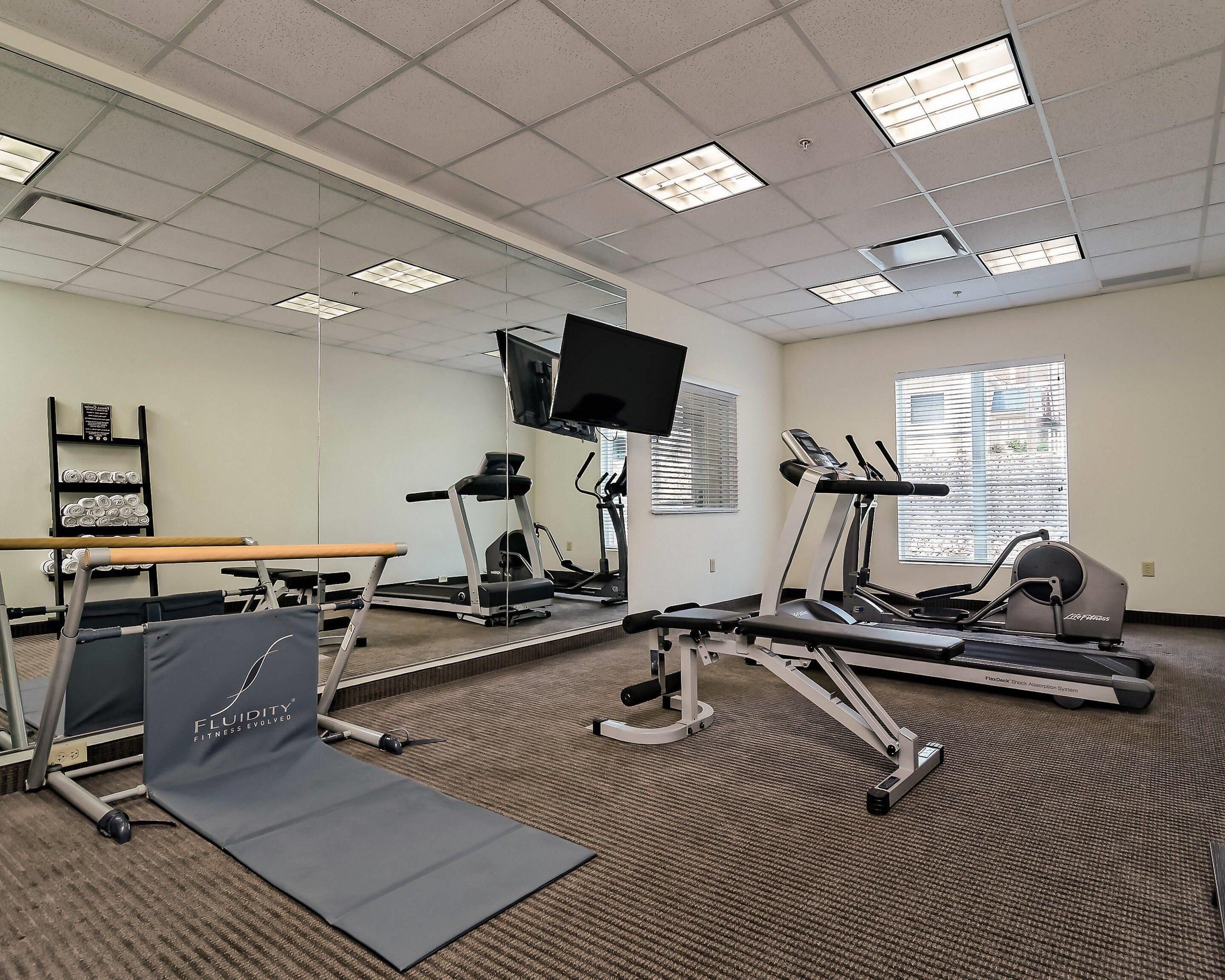 A fitness center with treadmills, a stationary bike, and a weight bench.
