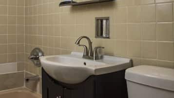 Un baño con bañera, lavamanos e inodoro.