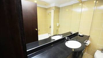 A bathroom with two sinks, a mirror, and a toilet.