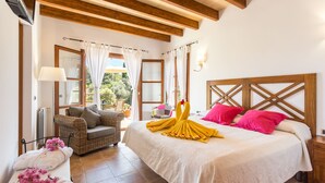 Une chambre à coucher comprenant un lit, un canapé, une table de chevet et une fenêtre avec des rideaux.