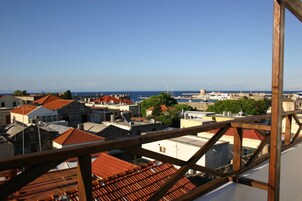 A coastal town with red-roofed buildings and a clear view of the sea.