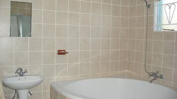 Un baño con bañera, lavamanos y ducha.