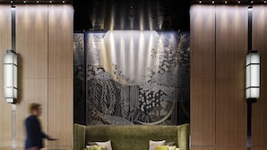 A modern lobby with a green sofa, a trash bin, and a patterned wall. - Millennium Mitsui Garden Hotel Tokyo/Ginza (Tokyo)