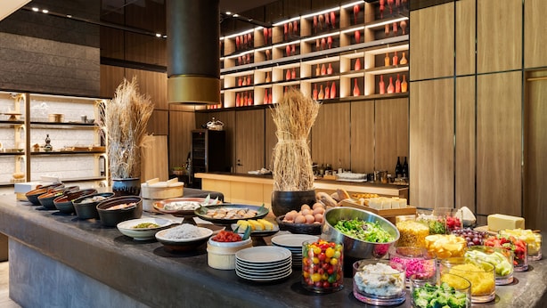 A buffet with various food items and a modern kitchen in the background. - Millennium Mitsui Garden Hotel Tokyo/Ginza (Tokyo)