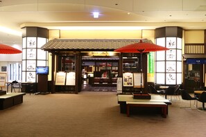 A traditional Japanese restaurant with tatami mats, low tables, and red umbrellas. - Air Terminal Hotel (Chitose)