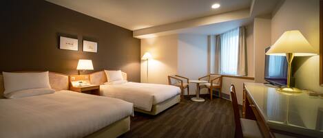 Une chambre d’hôtel avec deux lits, un bureau, une chaise, une télévision et une fenêtre avec des rideaux.