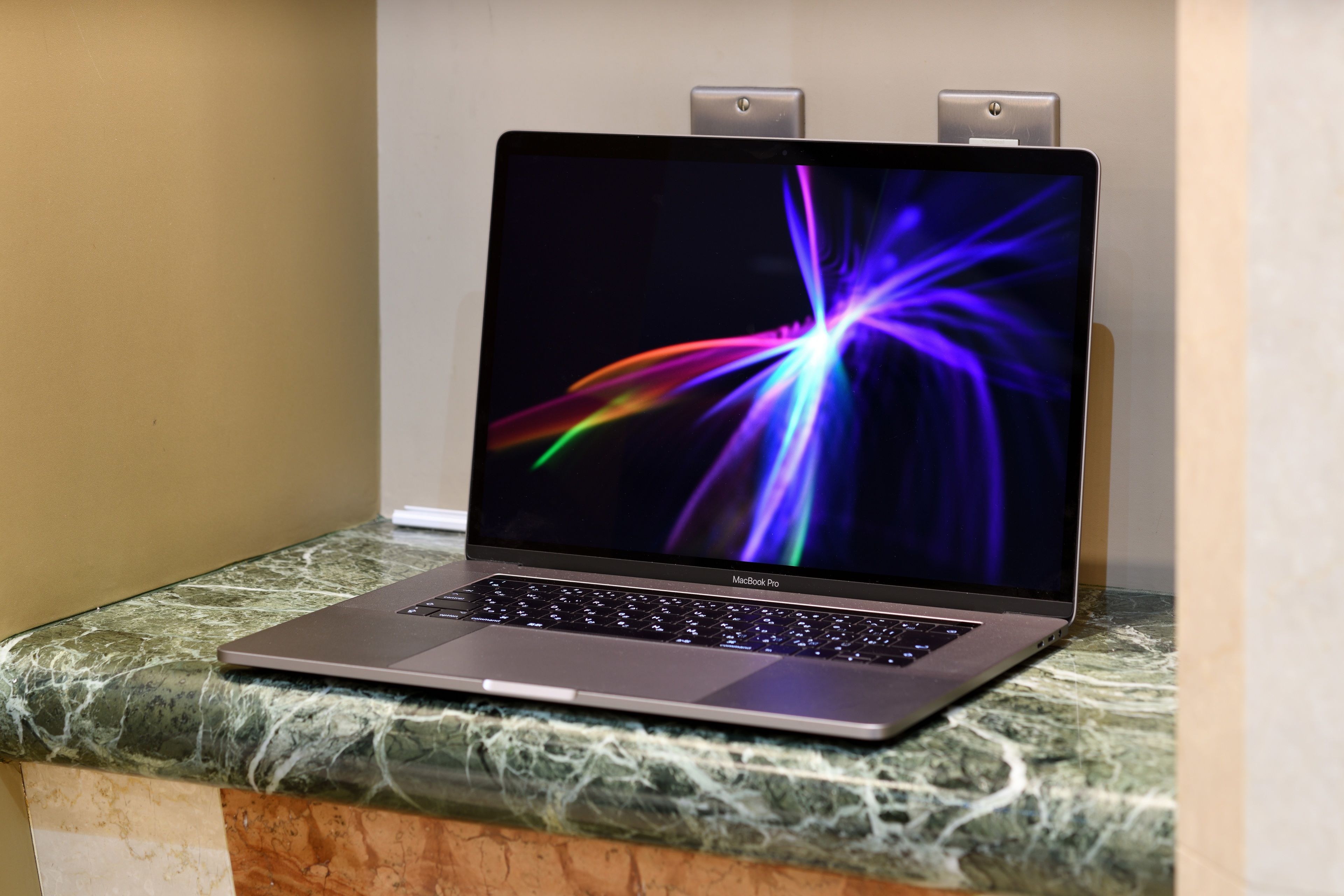 Una computadora portátil MacBook Pro sobre una encimera de mármol.