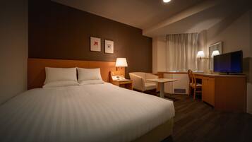 A hotel room with a large bed, a desk, a chair, a television, and a small table.