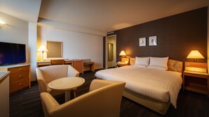 A hotel room with a bed, two bedside tables, a desk, a chair, a TV, and a lamp. - Air Terminal Hotel (Chitose)