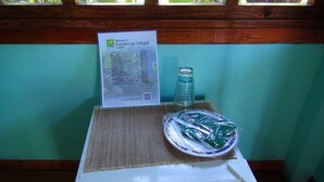 Une carte des boissons est posée sur une table, à côté d’une bouteille et d’une assiette de nourriture.