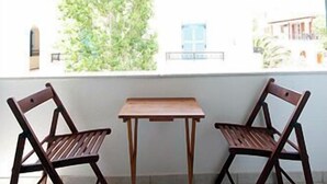 Une terrasse couverte avec deux chaises en bois et une table.