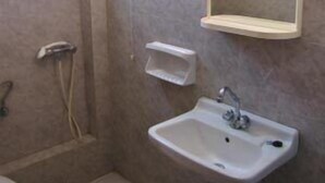 Une salle de bain équipée de toilettes, d’un lavabo et d’une douche.