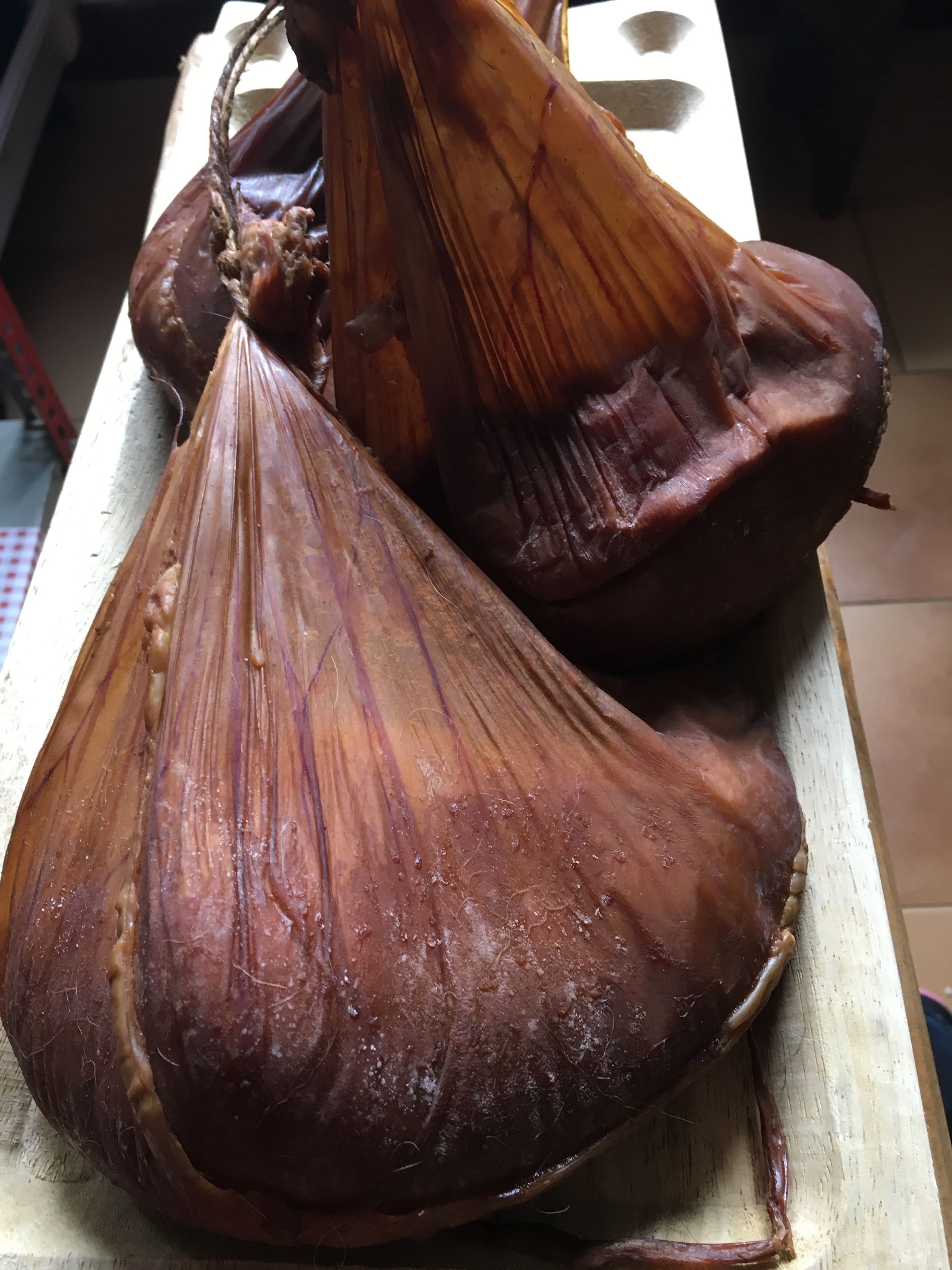 A wooden cutting board with two large, dried plant roots.