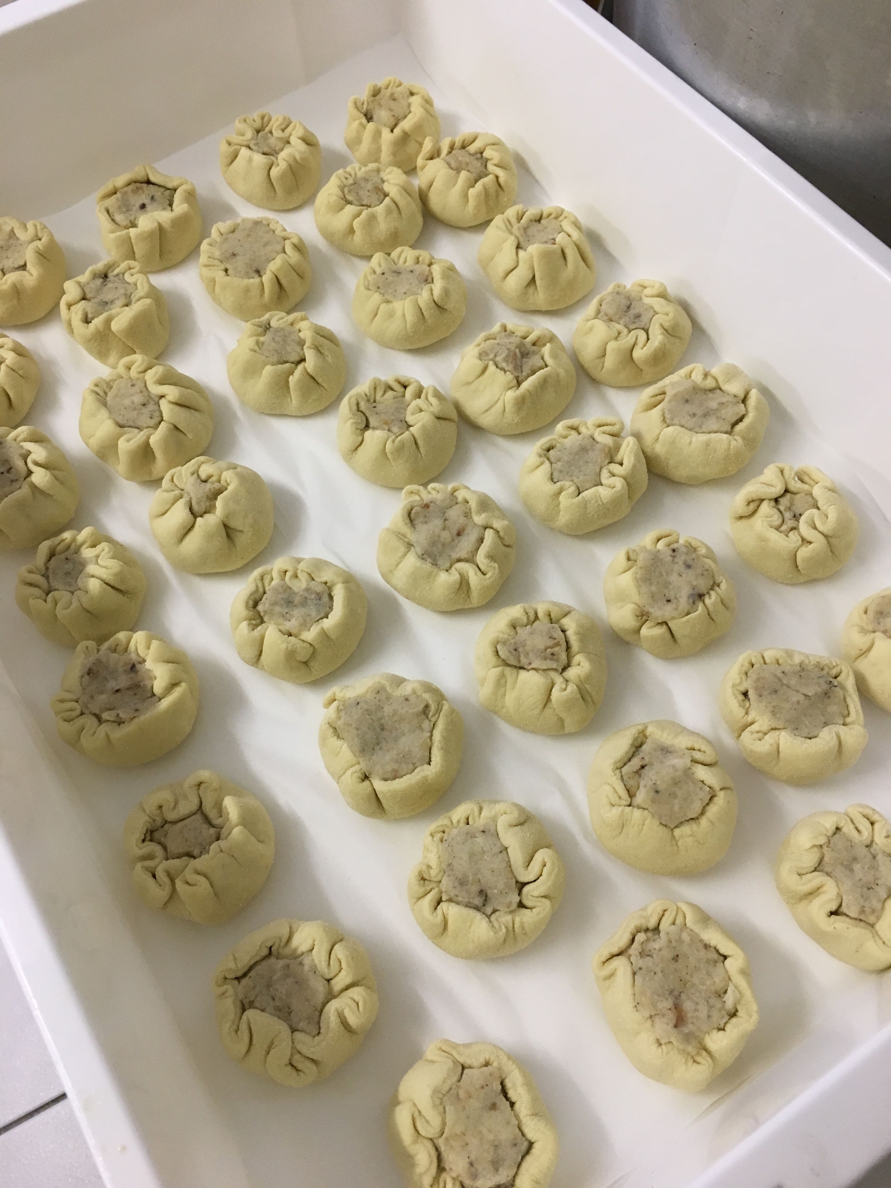 Une assiette de raviolis disposés en rangées.