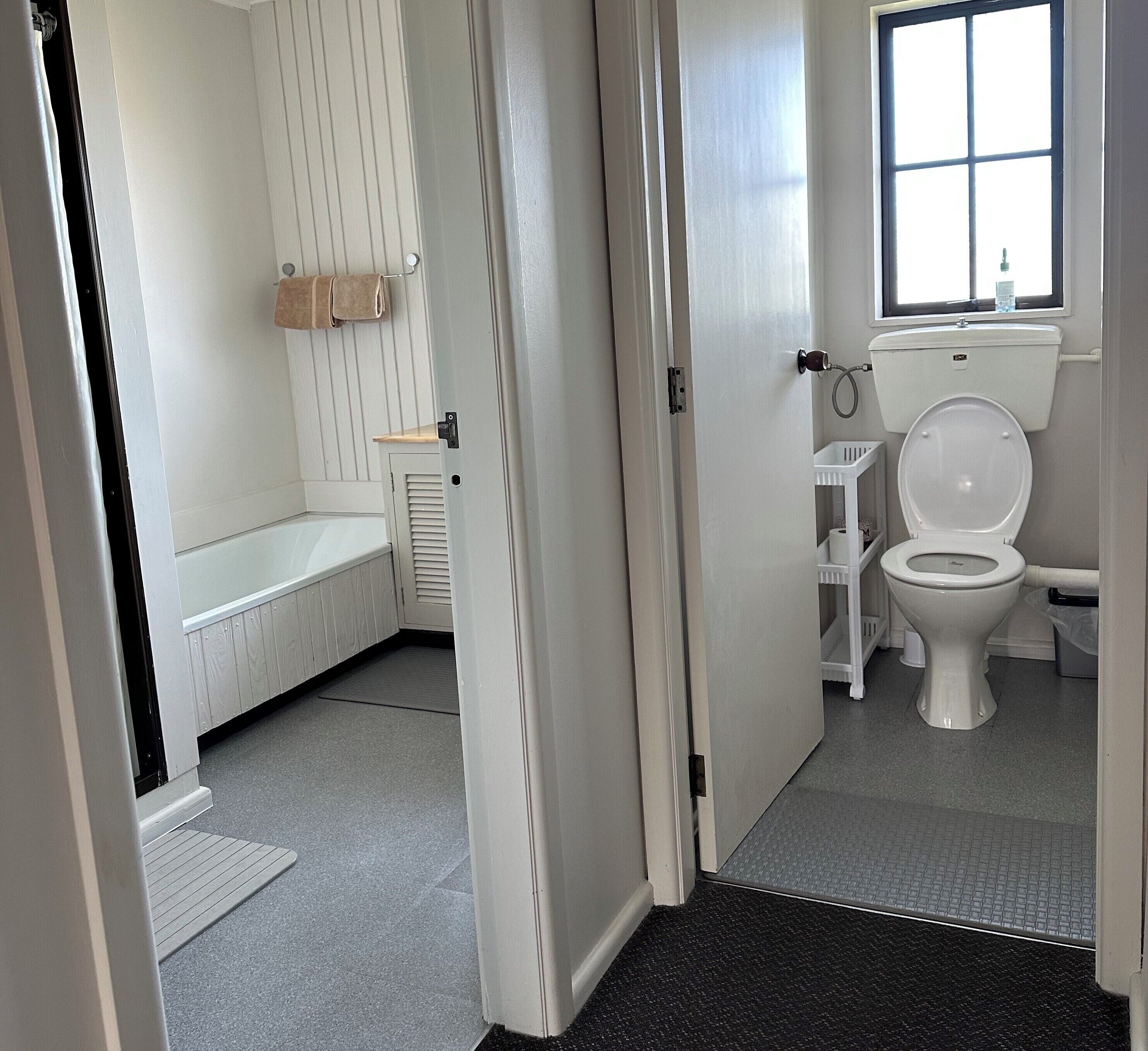 Een badkamer met een toilet, wastafel en bad.