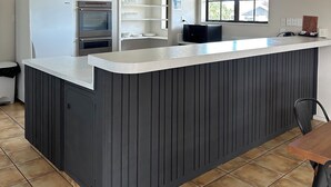 A kitchen with a built-in island, a refrigerator, an oven, and a window with a view. - Cherylea Motel (Blenheim)