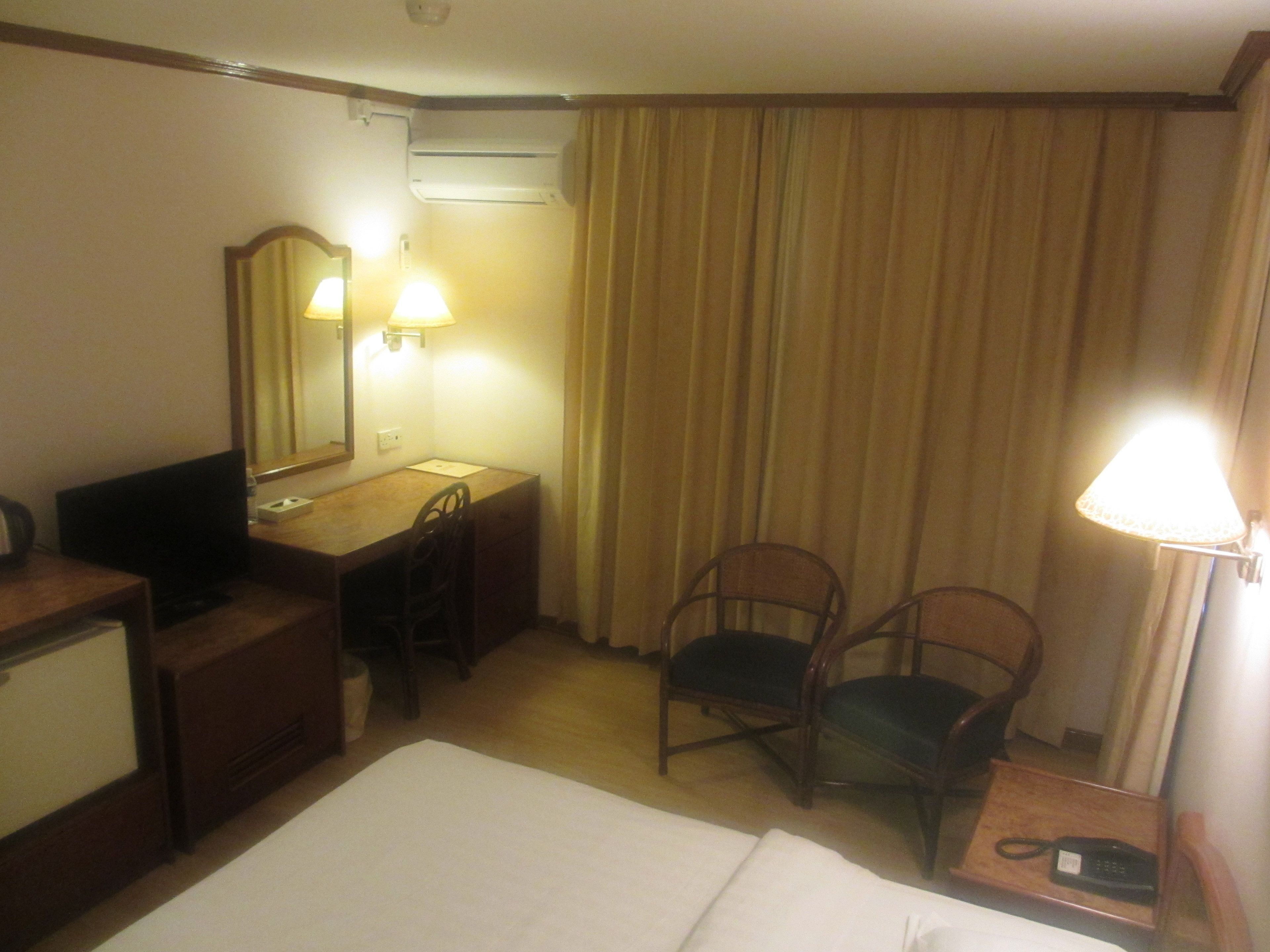 Una habitación de hotel con cama, escritorio, silla y teléfono.