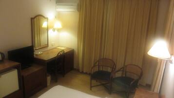 Una habitación de hotel con cama, escritorio, silla y teléfono.
