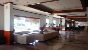 A spacious lobby with a seating area, large windows, and a tiled floor. - Sanbay Hotel (Sandakan)