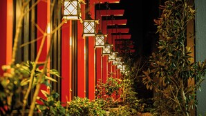 A pathway lined with red structures and lanterns, leading to a building. - Hotel Asyl Nara (Nara)