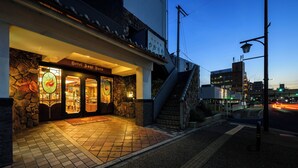 A hotel entrance with a stone facade, a staircase leading to the upper floor, and a street view with traffic lights. - Hotel Asyl Nara (Nara)