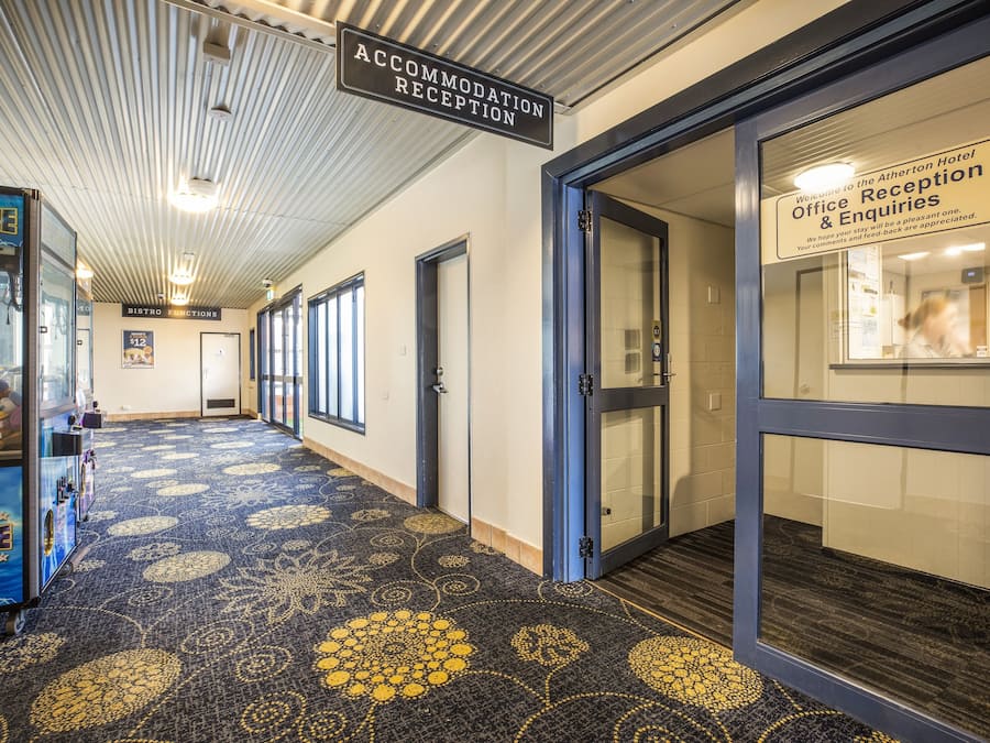 A hotel reception area with a reception desk, a bistro, and a vending machine.