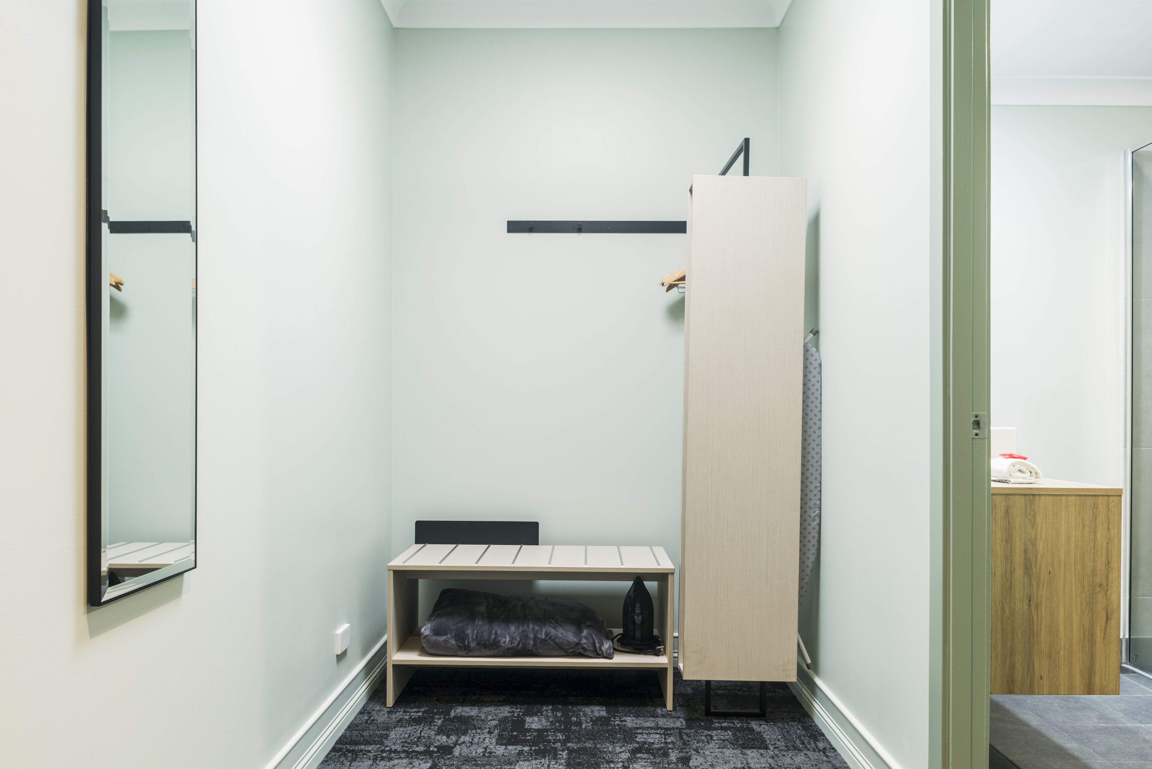 Une petite pièce, de taille modeste, comprenant un lit, une armoire et une étagère.