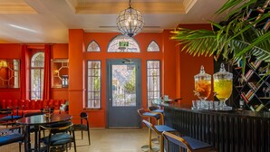 Un restaurant doté d’un bar, de murs rouges et d’une grande fenêtre.
