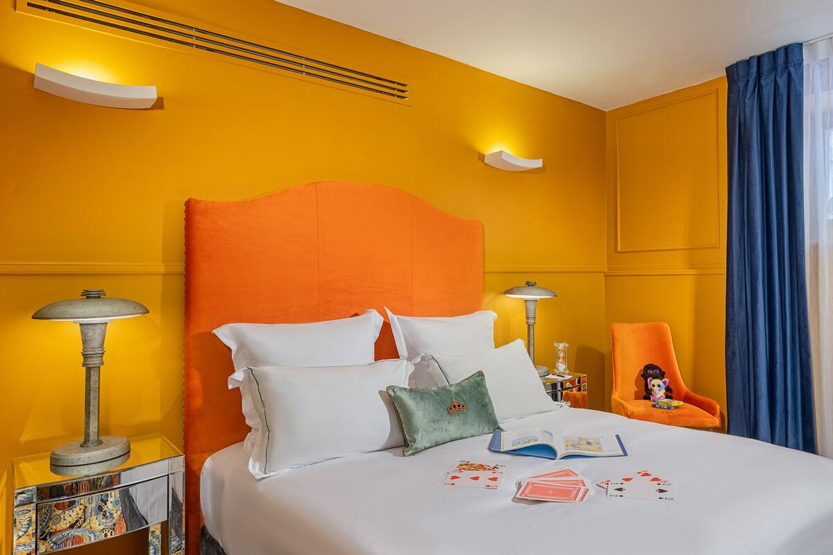 Une chambre d’hôtel avec un grand lit, une table de chevet, une lampe et une chaise.