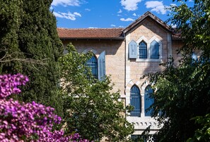 Ein historisches Steinhaus mit Rundbogenfenstern und einem Ziegeldach.