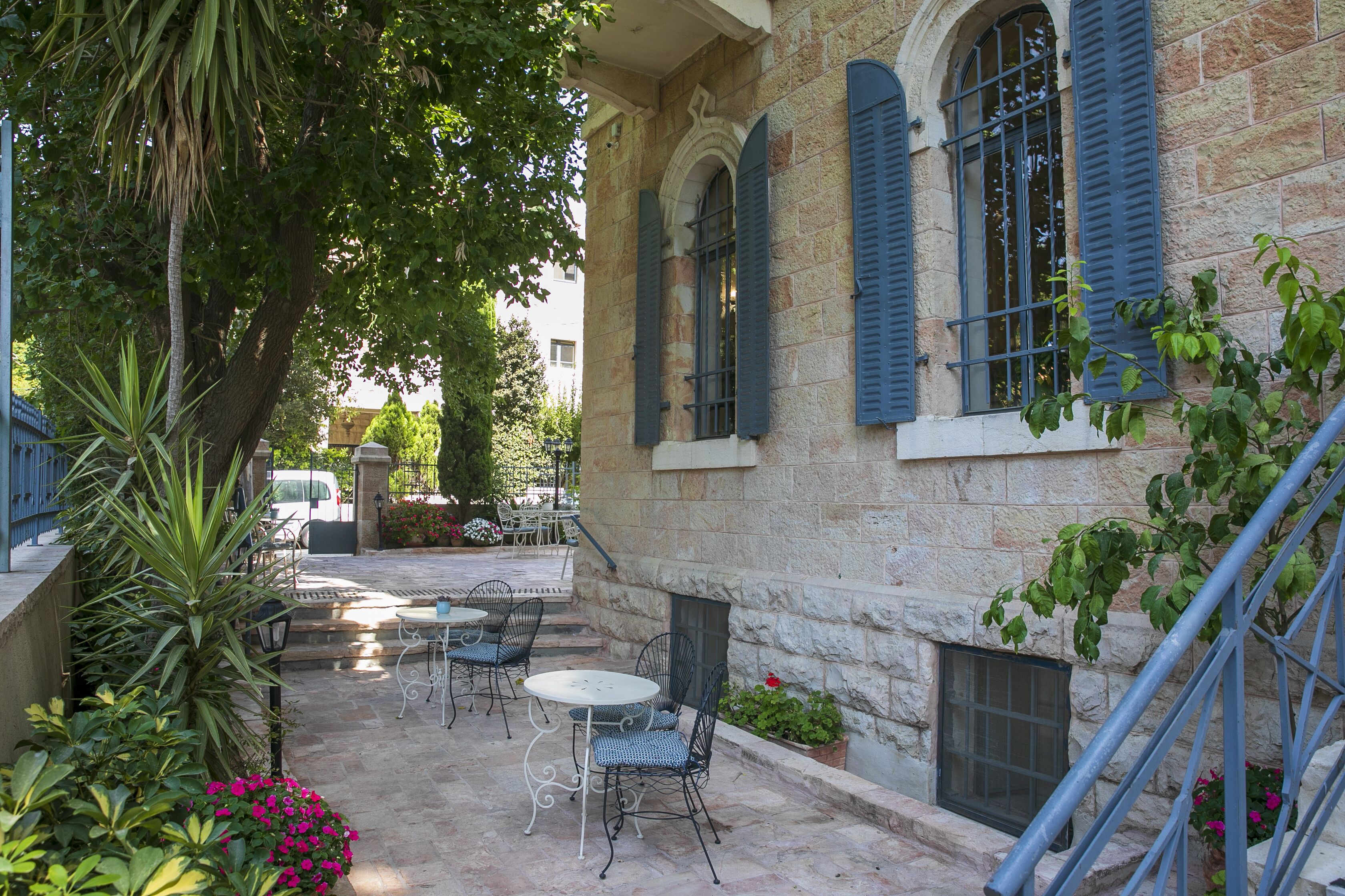 A courtyard with outdoor seating, stone walls, and a staircase.