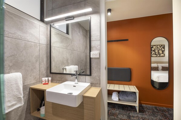 A modern bathroom with a large mirror, a white sink, and a wooden vanity. - Nightcap at Dalrymple Hotel (Garbutt)
