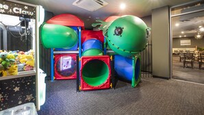 Zona de juegos con estructuras de escalada de colores y una máquina con pinzas.