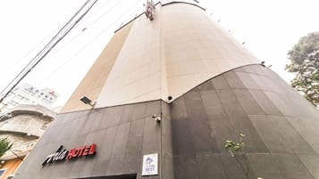 Un hôtel avec une enseigne bien visible, une caméra de surveillance et une plaque indiquant sa catégorie.