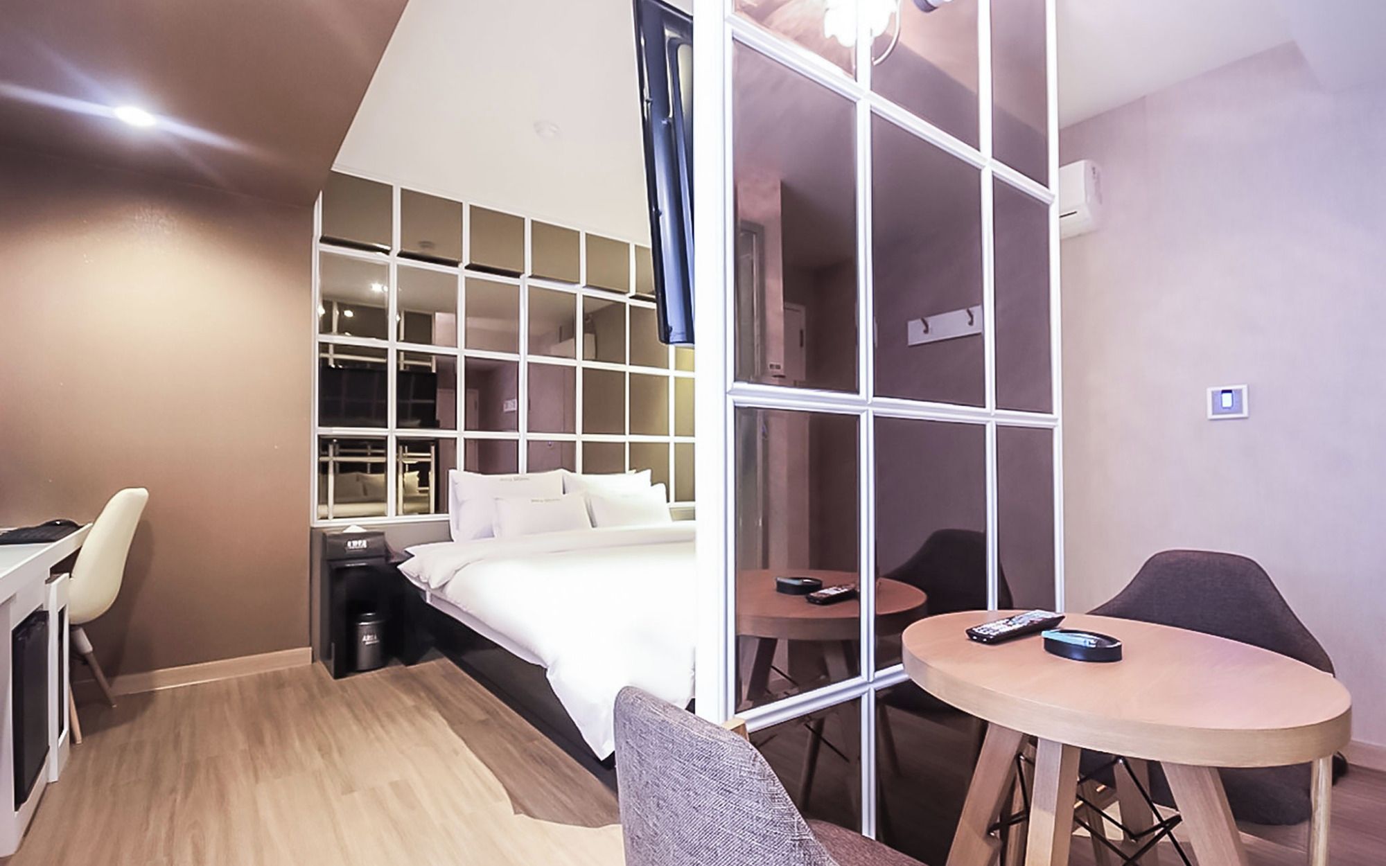 Une chambre d’hôtel équipée d’un lit, d’un bureau, d’une chaise, d’une petite table et d’un téléviseur.