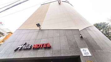 En moderne hotels bygning med et tydeligt skilt, hvor der står 'Asia Hotel'.