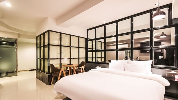 A modern hotel room with a large bed, a desk, and a seating area. - Hotel Aria Nampo (Busan)