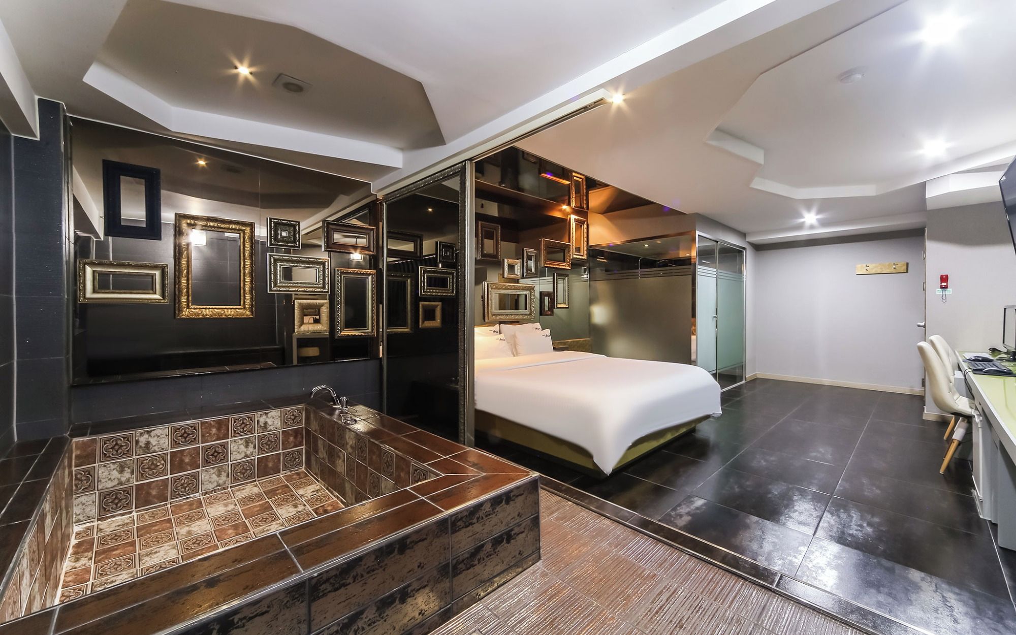 Una habitación de hotel moderna con una cama grande, un baño separado con bañera y un espacio de trabajo.