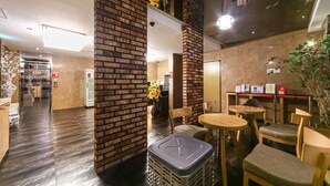 A modern interior with brick pillars, wooden furniture, and a reception area. - Hotel Aria Nampo (Busan)
