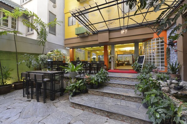 A courtyard with stone steps, outdoor seating, and potted plants.