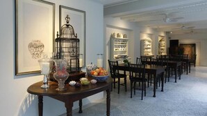 Un comedor con una mesa larga, sillas y un centro de mesa decorativo.