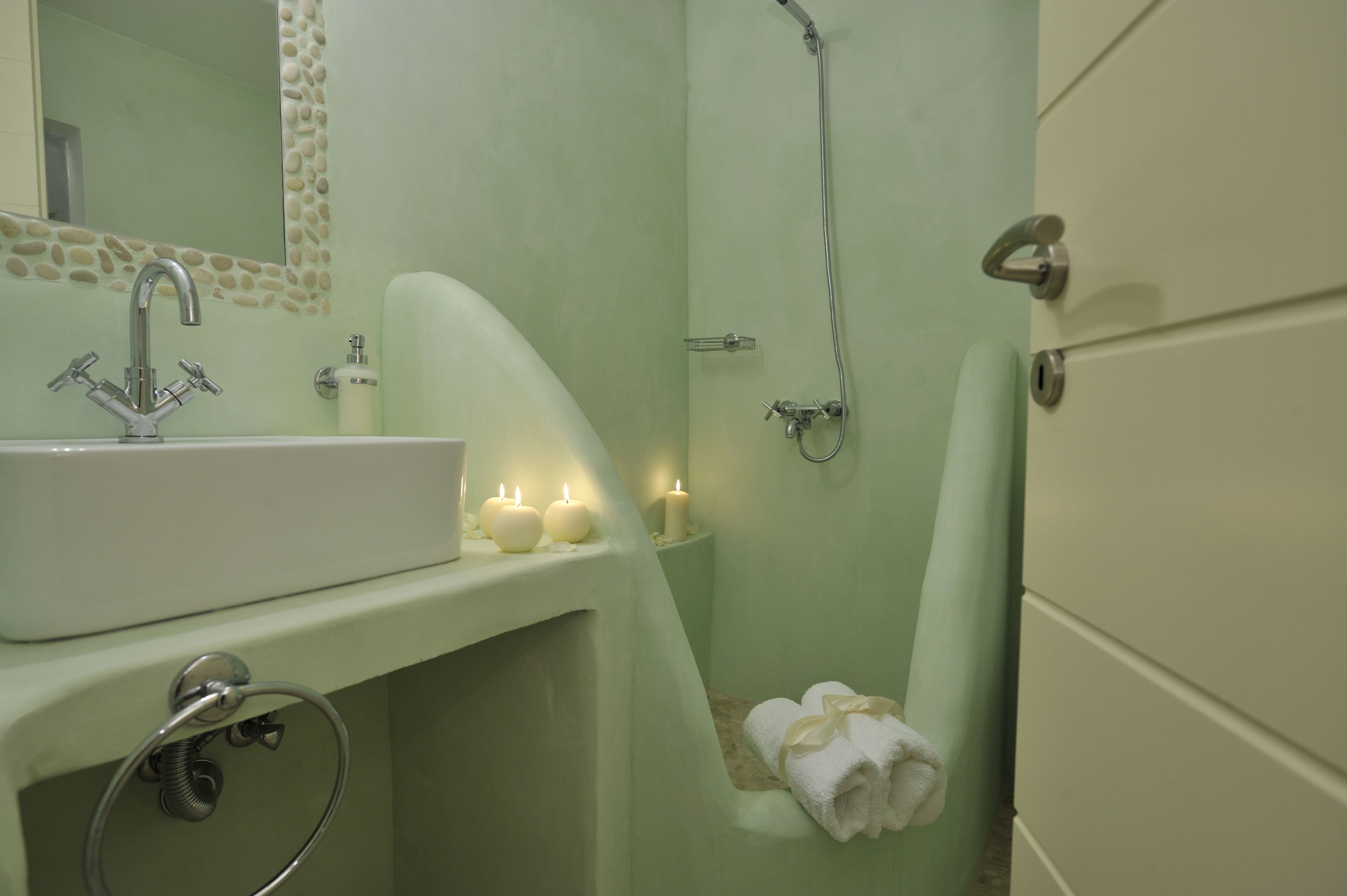 Un baño con lavamanos, espejo y ducha.