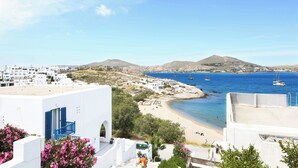 A coastal town with white buildings, a beach, and boats in the water. - Villa Isabella Studios & Suites (Paros)