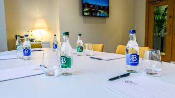 A conference table with water bottles, glasses, and notepads, indicating a meeting setup.