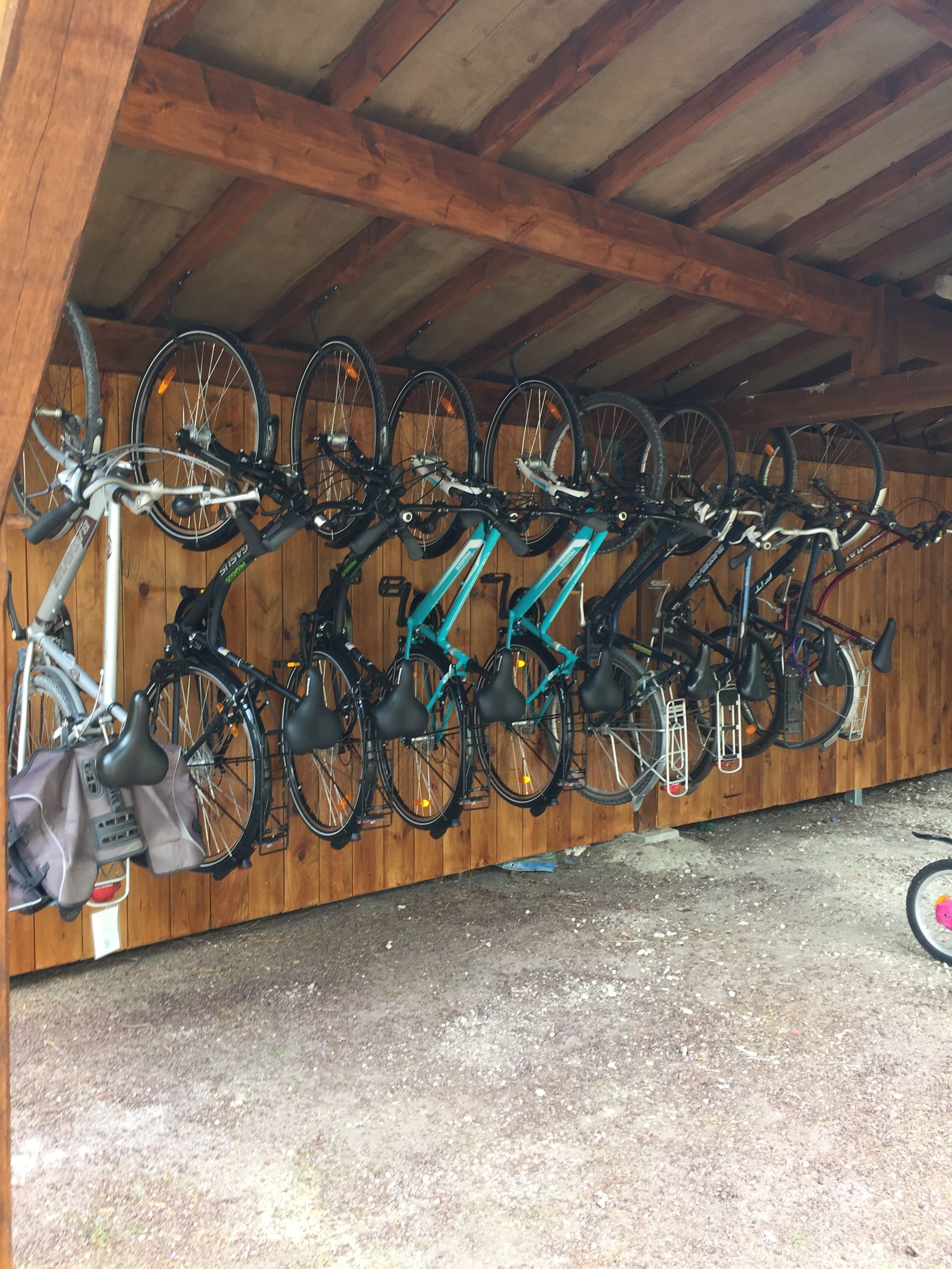 A covered bicycle storage area with multiple bikes secured on racks.