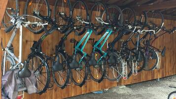A covered bicycle storage area with multiple bikes secured on racks.