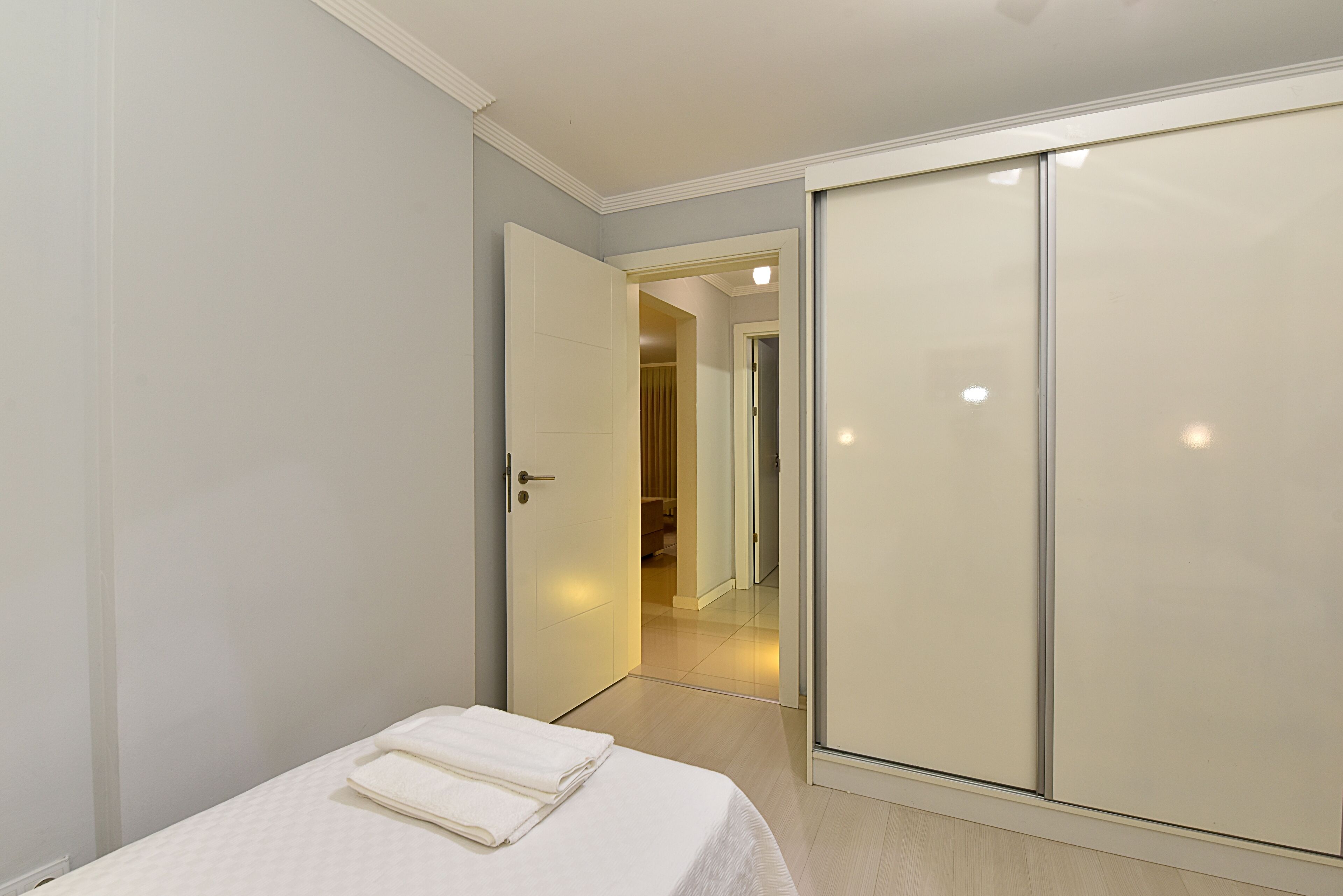 Un dormitorio con cama, armario y puerta que da a un baño.