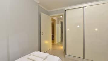 Un dormitorio con cama, armario y puerta que da a un baño.