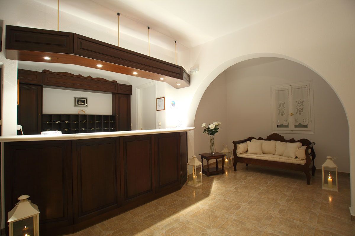 A spacious living area with a dark wood bar, a sofa, and a tiled floor.